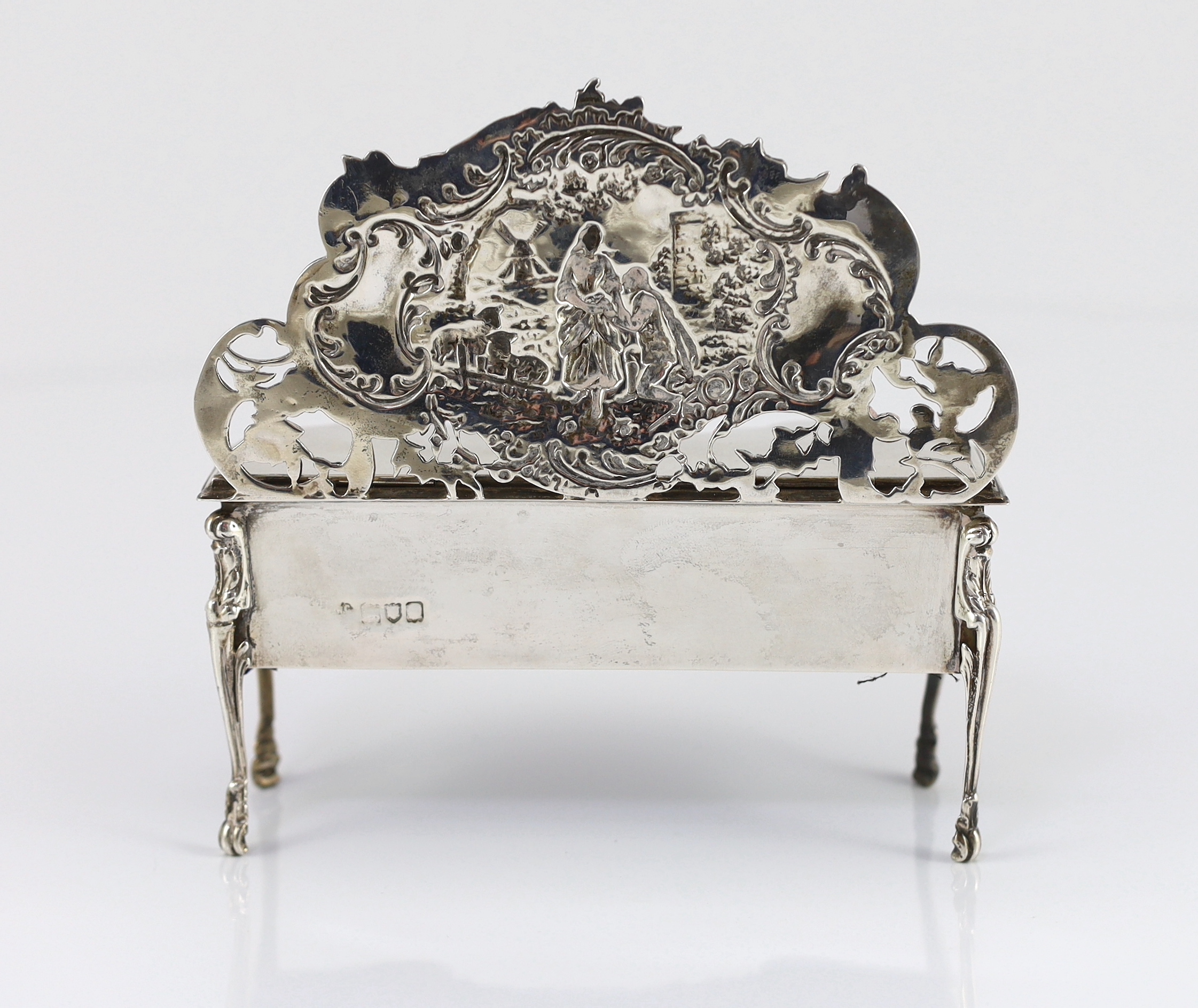 An Edwardian embossed silver novelty trinket box, modelled as a dressing table with raised back, on cabriole legs, by William Comyns